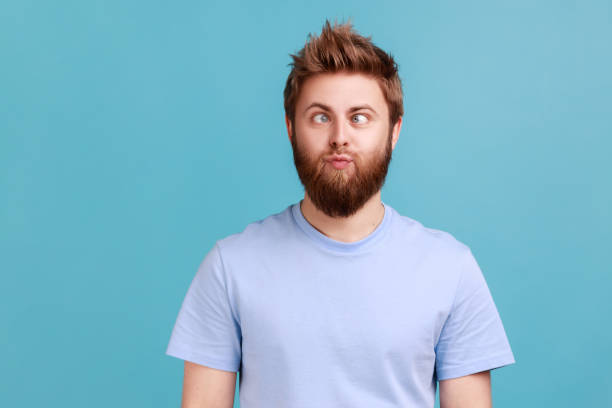 istock Man making silly humorous face with eyes crossed, showing comical silly brainless facial expression. 1675148063