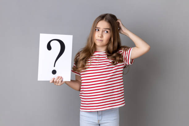 istock Little girl holding paper with question mark over, thoughtful, face thinking about question. 1675157285