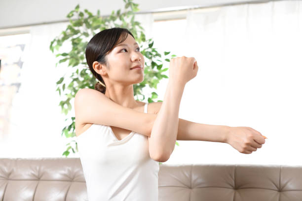 istock Young Asian woman stretching indoors 1675165034