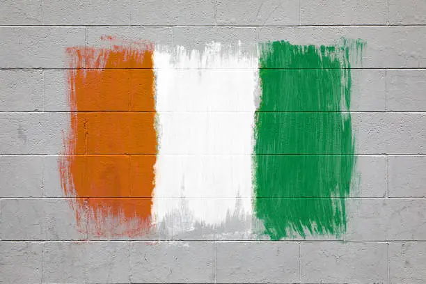 Close up of Ivory Coast flag colors green, white and orange painted on brick wall
