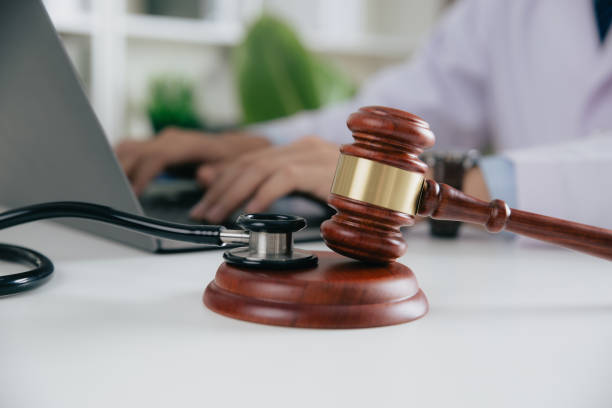 gavel with medical stethoscope while doctor using laptop. - patient stethoscope gavel hammer imagens e fotografias de stock