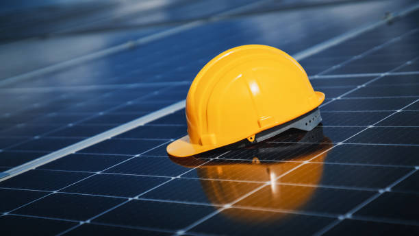 istock Yellow engineer hard safety helmet hat on solar cell panel. Solar panel and Clean energy concept. 1675300266