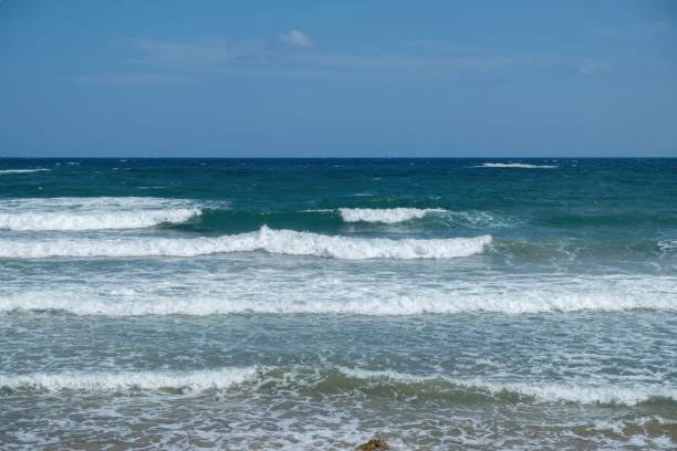 istock Tranquil tropical beach with crystal-clear waters and rolling waves lapping against the shore 1675300715