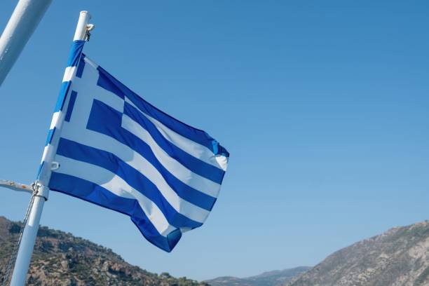 istock Blue and white Greek flag displayed on a flagpole, gently swaying in the wind 1675300732