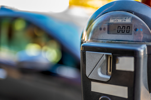 Selective focus on an expired parking meter with no time left.