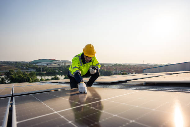 istock Professional engineer work to maintenance of photovoltaic panel system. Attractive technician worker working on roof inspect and check solar cell panels equipment box at solar cell field during sunset 1675306495