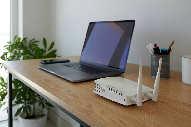 wifi router next to laptop - nodoby imagens e fotografias de stock