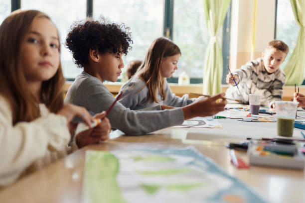 istock Group of school children painting on art class at elementary school. 1675314195