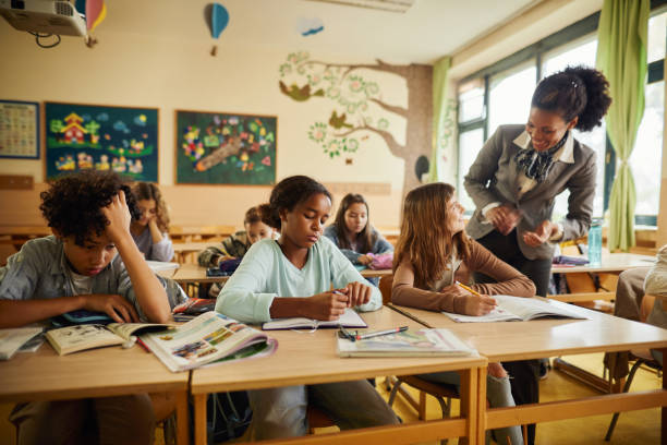 istock Happy black teacher talking to school kids on a class at elementary school. 1675316289