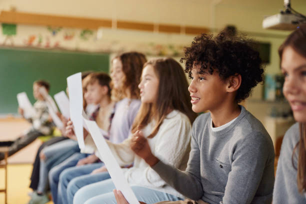 aluno negro feliz praticando com partituras em uma aula na escola. - sheet music music classroom education - fotografias e filmes do acervo