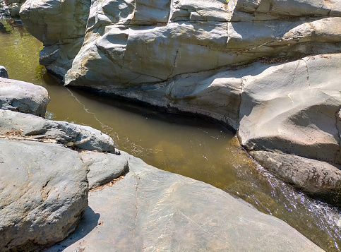 Water and Rocks Along Shoreline - Low angle view with selective focus on foreground rocks and pebbles.