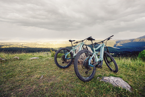 Mountain bike parked on a mountain summit with a great and clear view to the surrounding landscape.