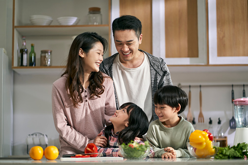 happy asian family with two children enjoying a good time together in kitchen at home