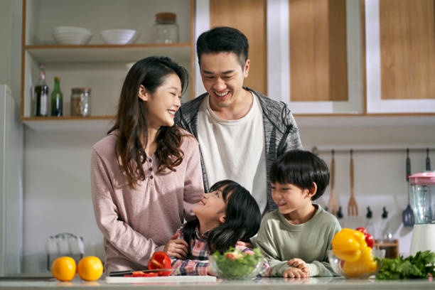 happy asian family with two children in kitchen at home stock photo