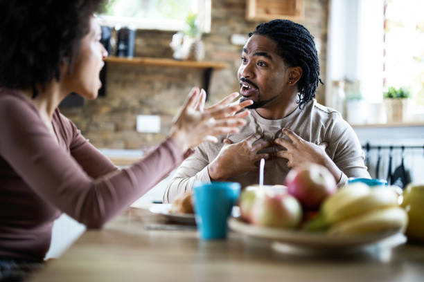 Angry black man arguing with his girlfriend during breakfast in the morning.