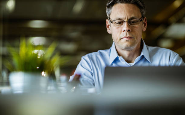 istock Male entrepreneur reading an e-mail on laptop in the office. 1675396763