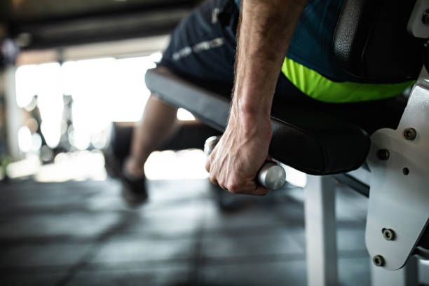 istock Close up of unrecognizable athletic man exercising on a machine in a gym. 1675415154