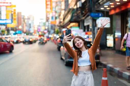 Young Asian tourists standing selfie taking a photo. Young woman beautiful tourists in Chinatown street food market, Bangkok, Thailand