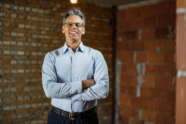 istock Confident male architect with crossed arms at construction site. 1675438455