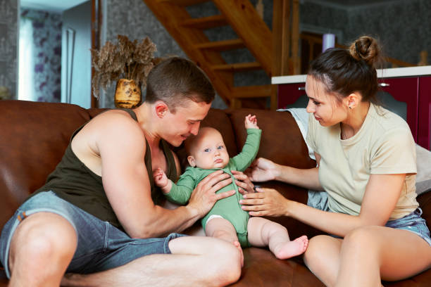 istock Young parents with six month old baby are sitting on leather sof 1675446898