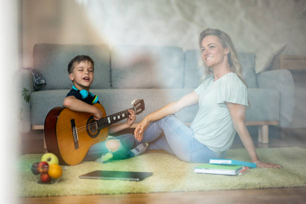 istock A boy plays the guitar for his mother at home 1675457740