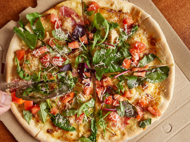 istock Freshly baked pizza is cut into pieces with a disk knife. View from above. 1675479777