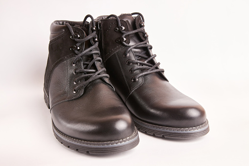 Black leather men's boots on a white background. Warm shoes for winter.