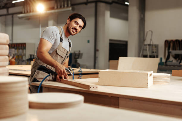 istock Young carpenter making wood furniture while working in joinery 1675504587