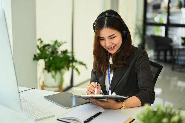 istock Positive female call center operator wearing headset working on computer in office 1675517981