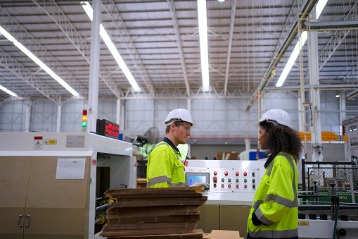Blue collar worker work at cardboard box manufacturing factory. Blue collar worker and factory concept.