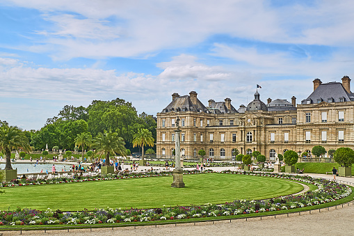 Paris, France - July 11, 2023: Crowd in the Jardin du Luxembourg with the Palais du Luxembourg.