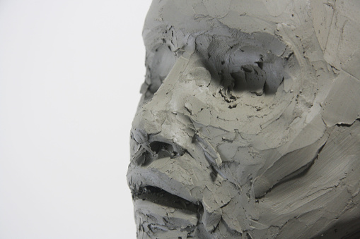 Close up face sculpture. Details clay material, female portrait without eyes. Fine art, artwork process, figurative art.