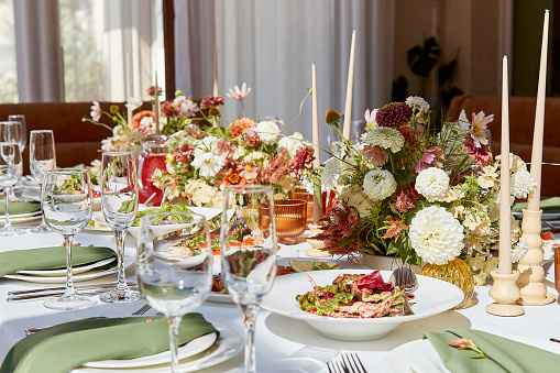 Elegant summer table setting with candles and flowers design. Restaurant chamber event in provence style.