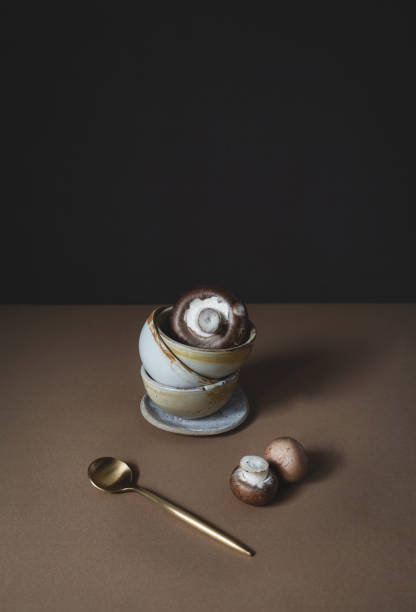 istock Mushrooms in Ceramic Bowls with a Golden Coffee Spoon 1675570604