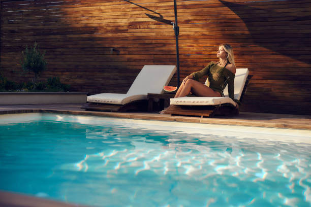istock Sensual woman relaxing by the pool. 1675573395