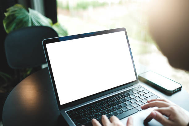 istock Mockup image of a businesswoman using laptop with blank white desktop screen with coffee cup on wooden table in cafe 1675585490