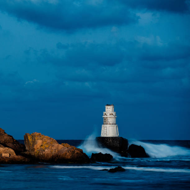 istock Big sea waves hitting a lighthouse at night 1675592122