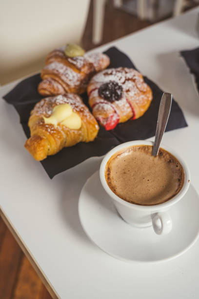 istock breakfast with cup of coffee and croissants on a white table. Front view 1675602581