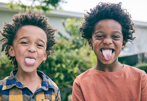 Children, portrait and brothers with tongue out in a backyard for fun, playing and sibling bonding outdoor. Family, love and kids with funny face, emoji and silly together in a garden on the weekend