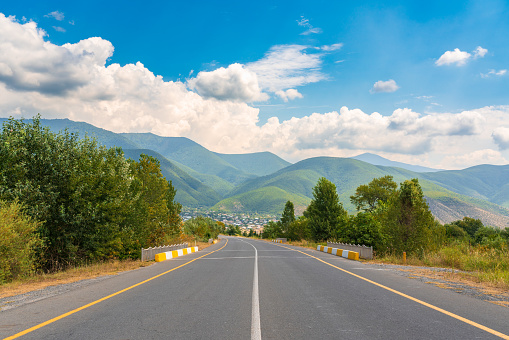 Empty asphalt highway to a mountain village