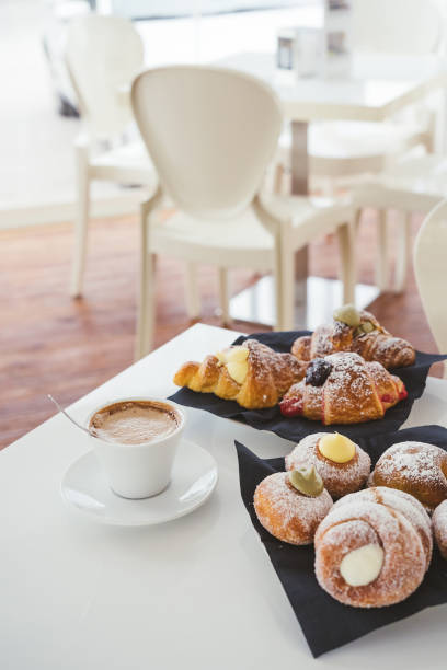 istock breakfast with cup of coffee and croissants on a white table. Front view 1675614167