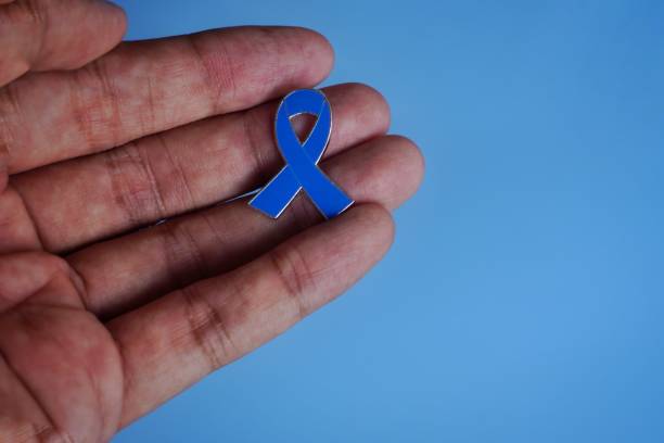 istock Hand holding blue ribbon on blue background with copy space. 1675638225