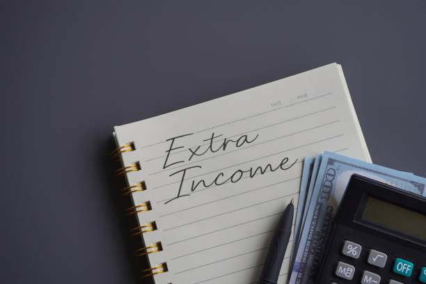 istock Top view image of calculator, money and notebook with text EXTRA INCOME. 1675638228