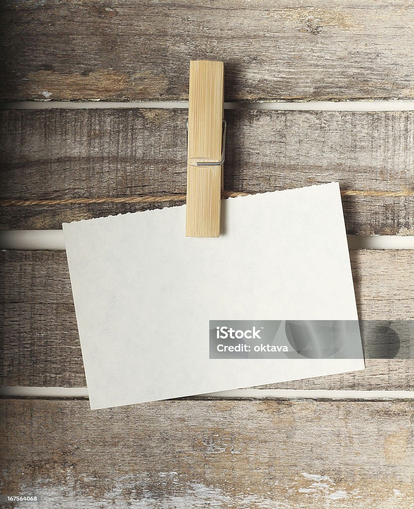 Paper note with a pinch Paper note with a pinch on wooden background Postcard Stock Photo