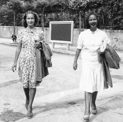 Two young women twin walking in a street in 1934.