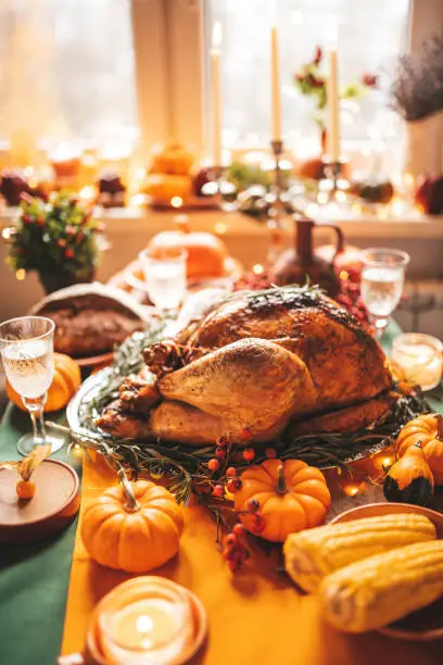 Photo of Thanksgiving holiday dinner table setting with fall decoration and pumpkins