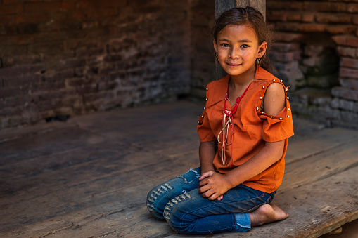 Portrait of young Nepali girl posing in an ancient town of Bhaktapur. Bhaktapur is an ancient town in the Kathmandu Valley and is listed as a World Heritage Site by UNESCO for its rich culture, temples, and wood, metal and stone artwork.