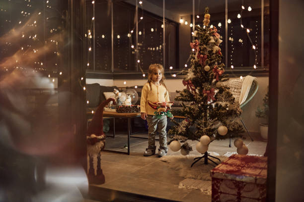istock Happy girl decorating Christmas Tree 1675705003