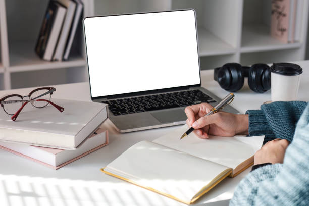 istock Asian girl watch studying online using applications, app, e learning distance training course at home. Over shoulder view on mockup image on laptop computer with white screen. 1675708868