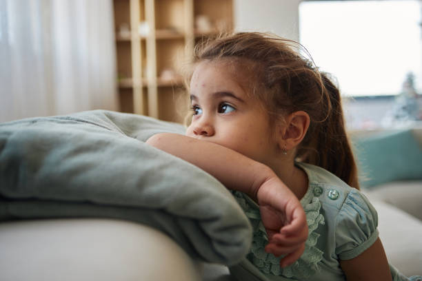 istock Small girl with chickenpox looking trough the window 1675721198
